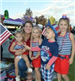 Kids and Woman Dressed in Red, White, and Blue