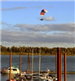 Person Flying over Water on Powered Parachute