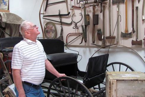 Man standing by a buggy at the Two Rivers Heritage Museum